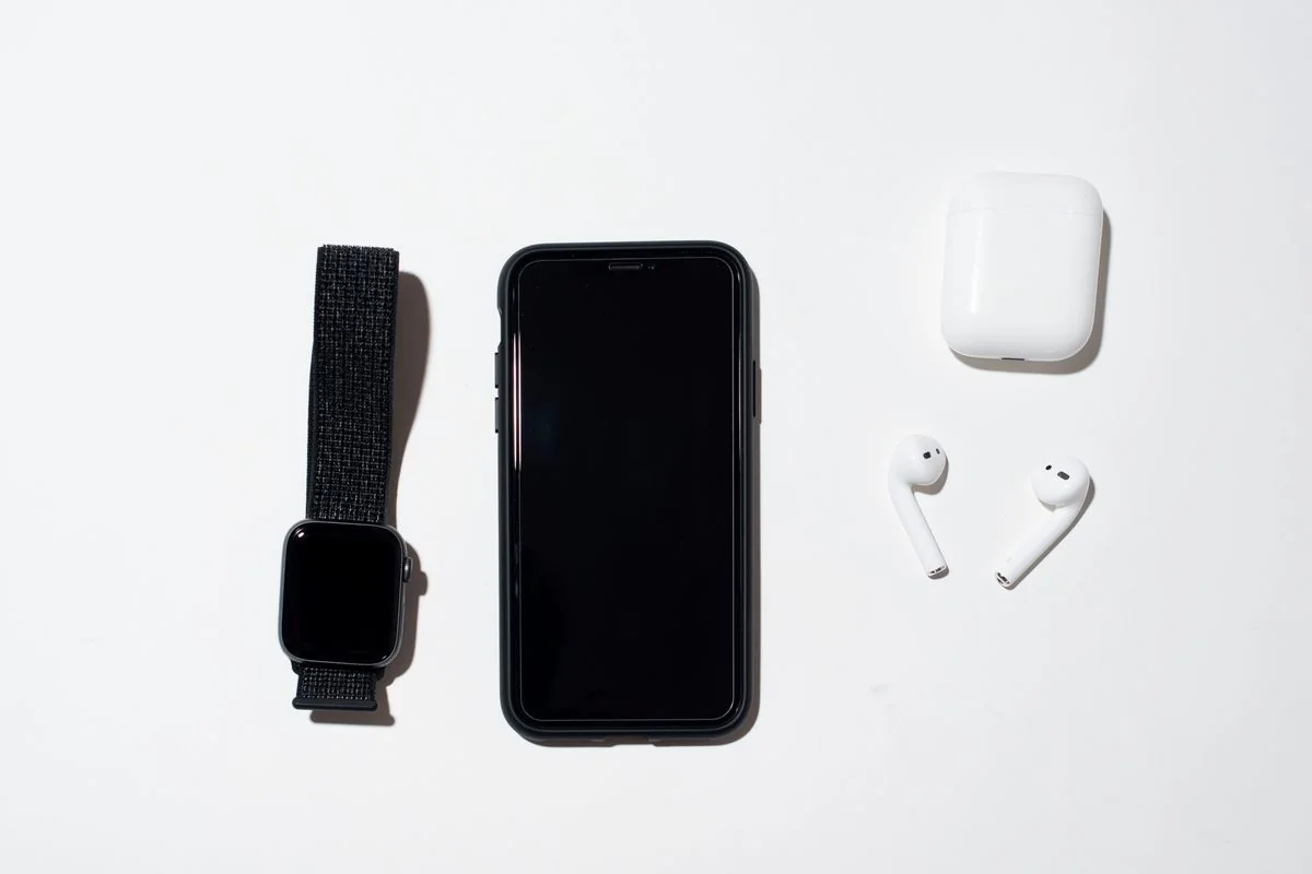 Smartphone, smartwatch e auricolari su un piano chiaro
